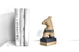 Title: Plinth Woman Artist: Sally Fitchard Medium: clay sculpture Size: 21.5 cm x 11 cm x 7.2 cm (in situ, on book-shelf with books). Colour comprises sand and charcoal