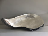 Lucy Gray's 'Shell I' is a large-scale depiction of an oyster shell made from jesmonite and gilded with silver leaf