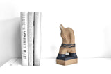 Title: Plinth Man Artist: Sally Fitchard Medium: clay sculpture Size: 14.8 cm x 9.2 cm x 8.4 cm (in situ, on a book-shelf beside books). Colours comprise sand and charcoal