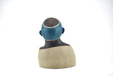 Title: Spaceman Artist: Sally Fitchard Medium: clay sculpture Size: 14 cm x 10.4 cm x 8.2 cm (back view). Colour comprises sand, charcoal and teal green
