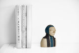 Title: Spaceman Artist: Sally Fitchard Medium: clay sculpture Size: 14 cm x 10.4 cm x 8.2 cm (in situ, on book shelf beside books). Colour comprises sand, charcoal and teal green