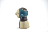 Title: Spaceman Artist: Sally Fitchard Medium: clay sculpture Size: 14 cm x 10.4 cm x 8.2 cm (side profile, left side). Colour comprises sand, charcoal and teal green