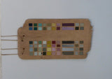 Abstract geometric artwork on driftwood, mounted on a white board