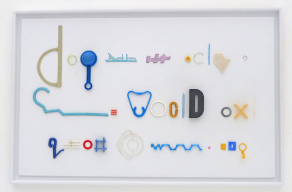 Fiona MacRae's 'Doggerel is an assemblage made from ocean plastic, mounted on white board and framed in a white frame. 