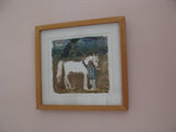Framed painting of a child with a horse on a wall