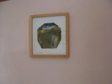 Framed picture of a landscape on a plain wall