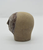Sally Fitchard's 'Mottle'. A small ceramic head with a mottled face. LEFT SIDE