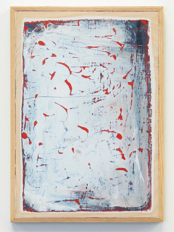 Abstract painting with red splashes on a white background in a wooden frame on a white wall