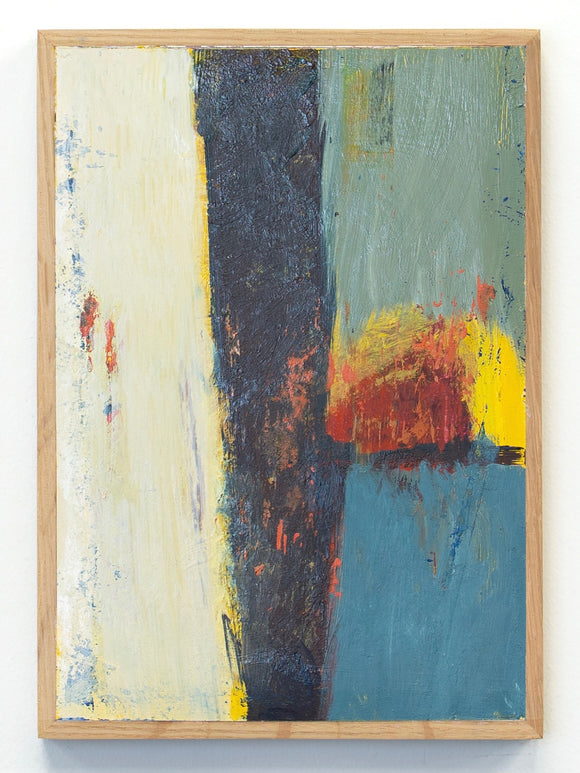Abstract painting with bold colors in a wooden frame on a white wall