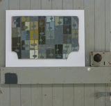 Abstract geometric artwork on a white background, sitting on a brace of a green/grey painted door