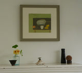 Photo of Fiona MacRae's 'French Green Fish' in situ. The artwork is framed in a wooden frame, which is painted in an olive green and mounted in off-white.